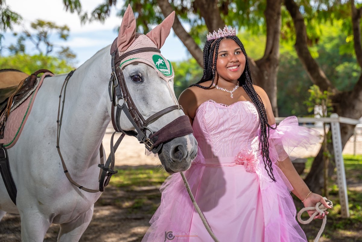 Ester Zion sorrindo ao lado do cavalo branco