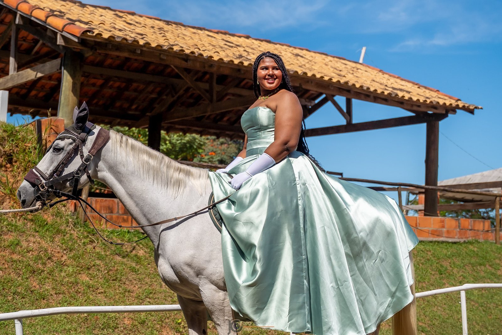 Ester Zion com vestido verde claro sobre cavalo branco